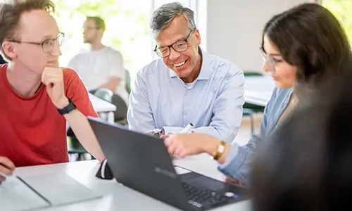 Studenter pluggar tillsammans med lärare.