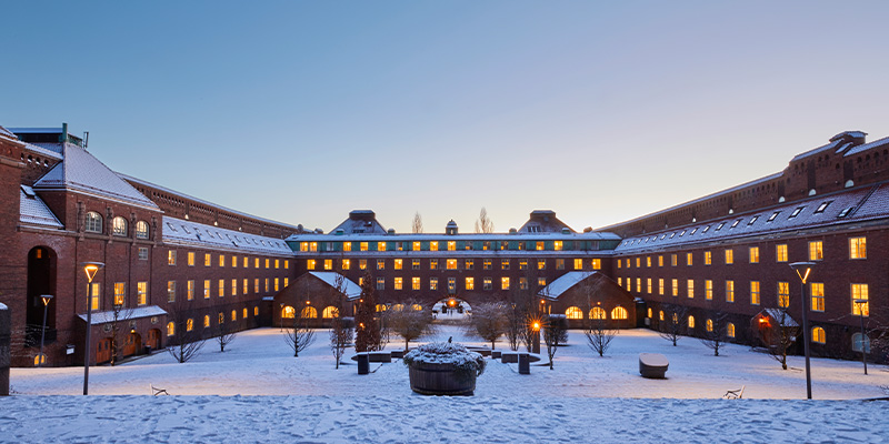 The courtyard at KTH Campus covered in snow at dusk