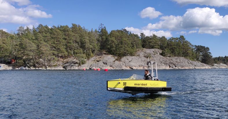 Ett bärplansbåt flyger över vattnet i skärgården utanför Djurö.