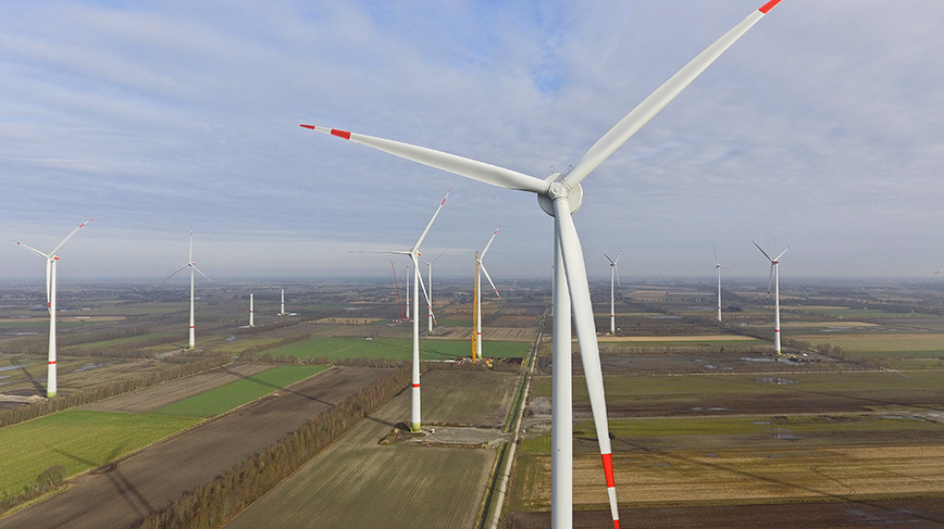 A view of wind turbines from, looking down from above on a vast plain