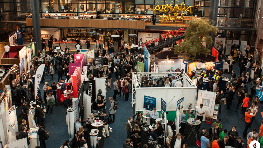 Overview image of the exhibition area at Armada where students and business owners are conversing.