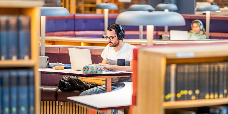 Person studying in KTH Library, wearing headphones