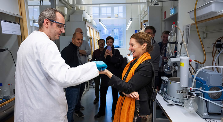 man in lab coat talking to a woman