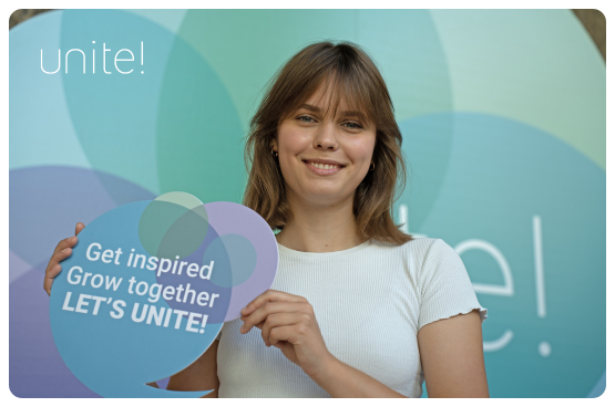 Female student holding a "Let's Unite" sign
