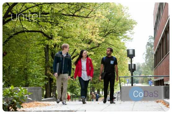 Three sudents walking through a park