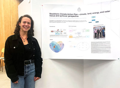 Young woman in front of a research poster.