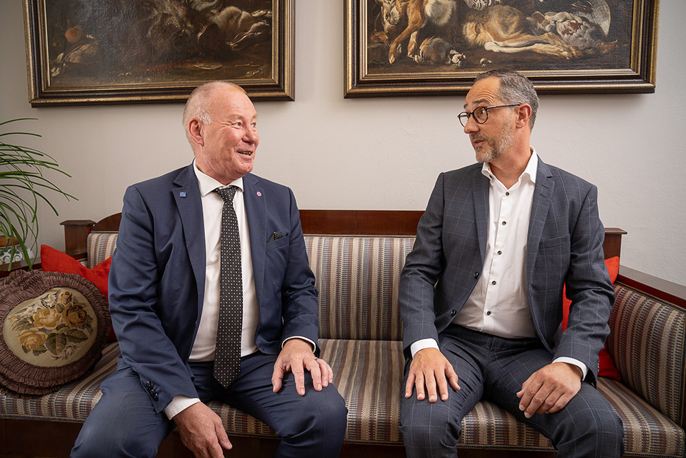 Two men sitting on a sofa.