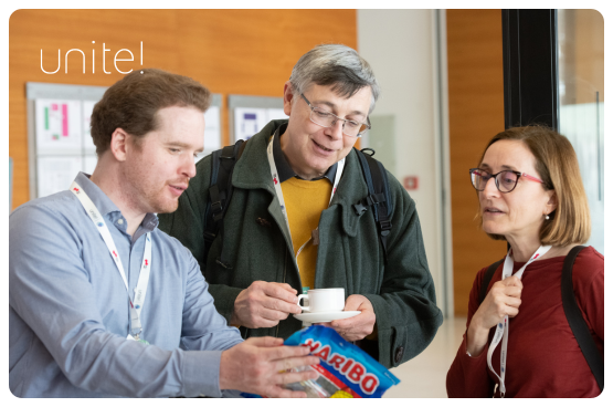 Three people looking at a packet of candy