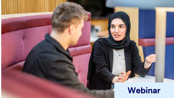 Two students talking in the library.