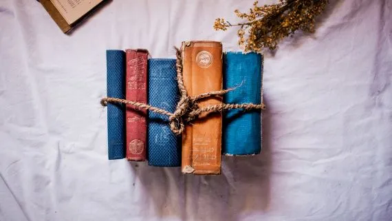 A stack of books tied together with a string