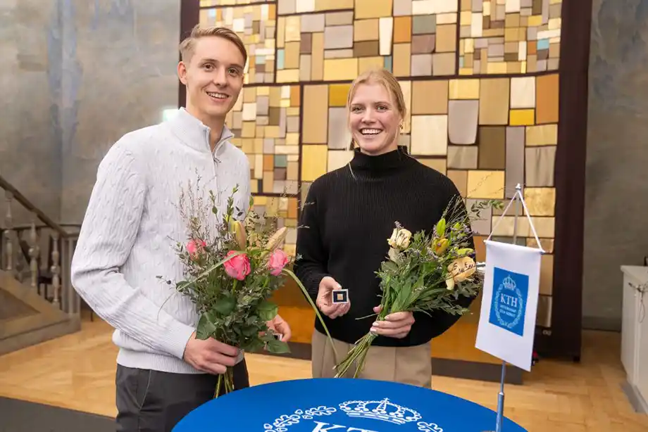 Två personer med blommor i famnen.