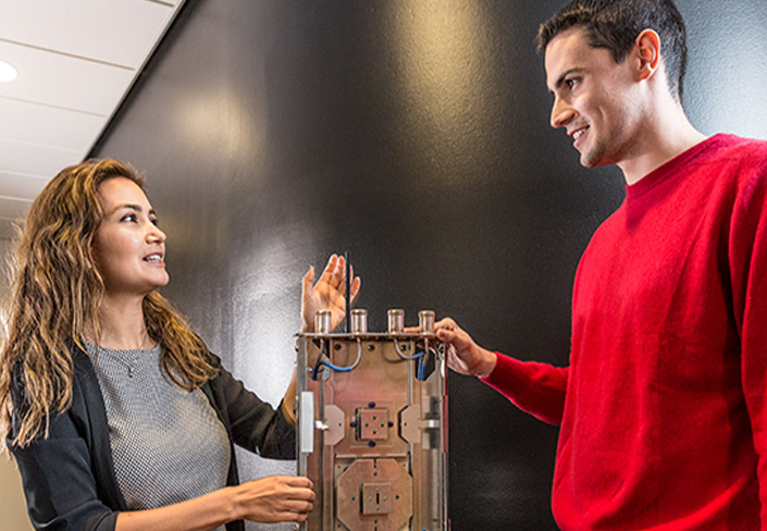 Kvinna och man undersöker teknisk utrustning