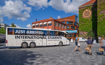 A bus with international students outside of KTH Entré