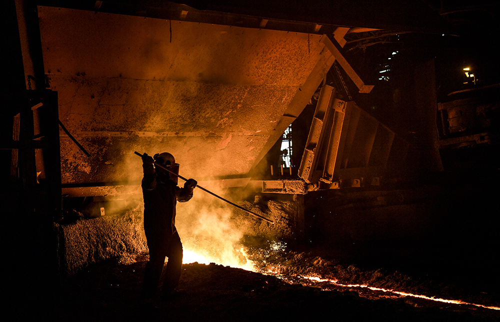 Stålverksarbetare vid en masugn i ett stålverk.
